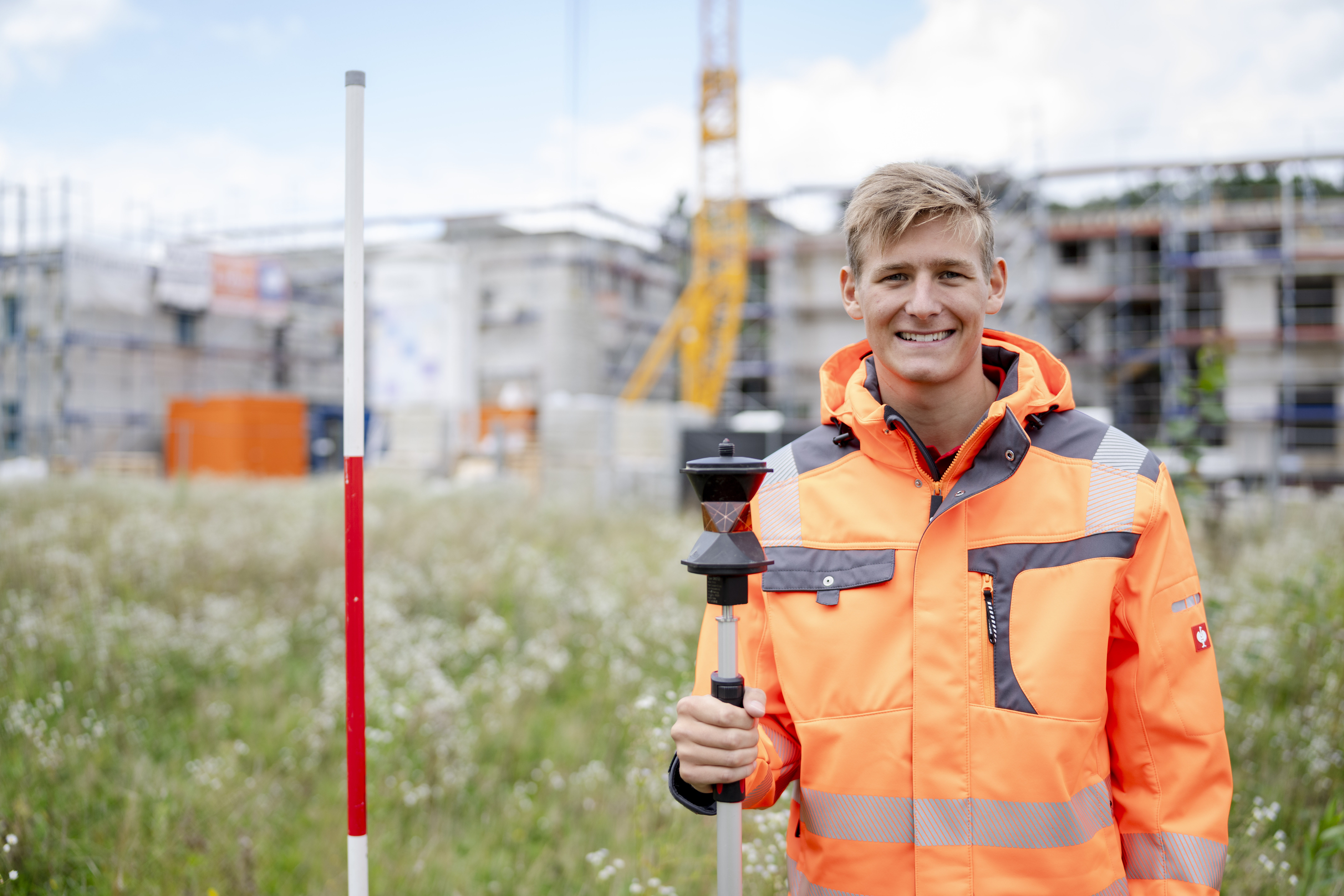 Freundliche:r Mitarbeiter:in des Unternehmens in Arbeitskleidung, lächelnd in die Kamera blickend