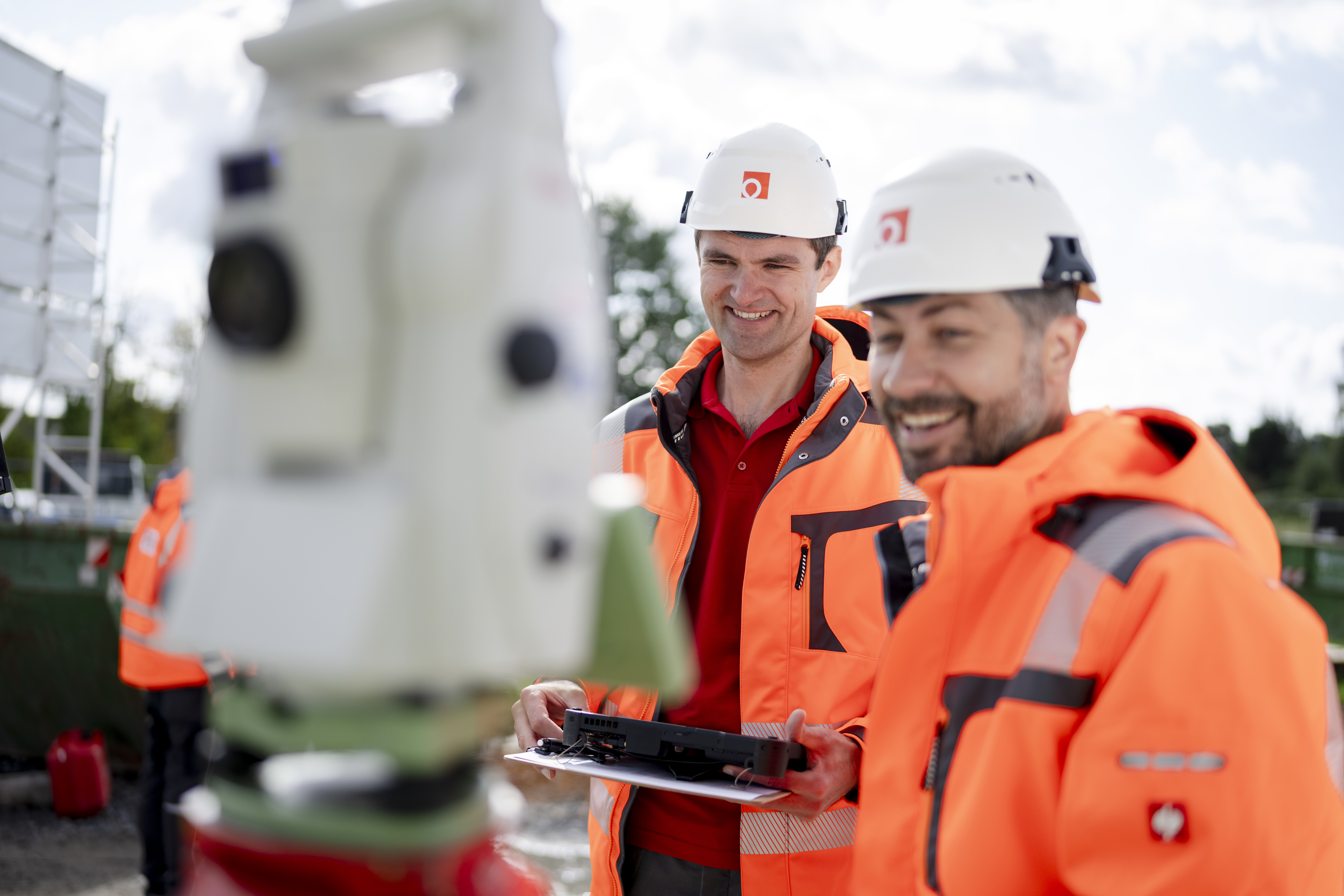 Freundliche:r Mitarbeiter:in des Unternehmens in Arbeitskleidung, lächelnd in die Kamera blickend