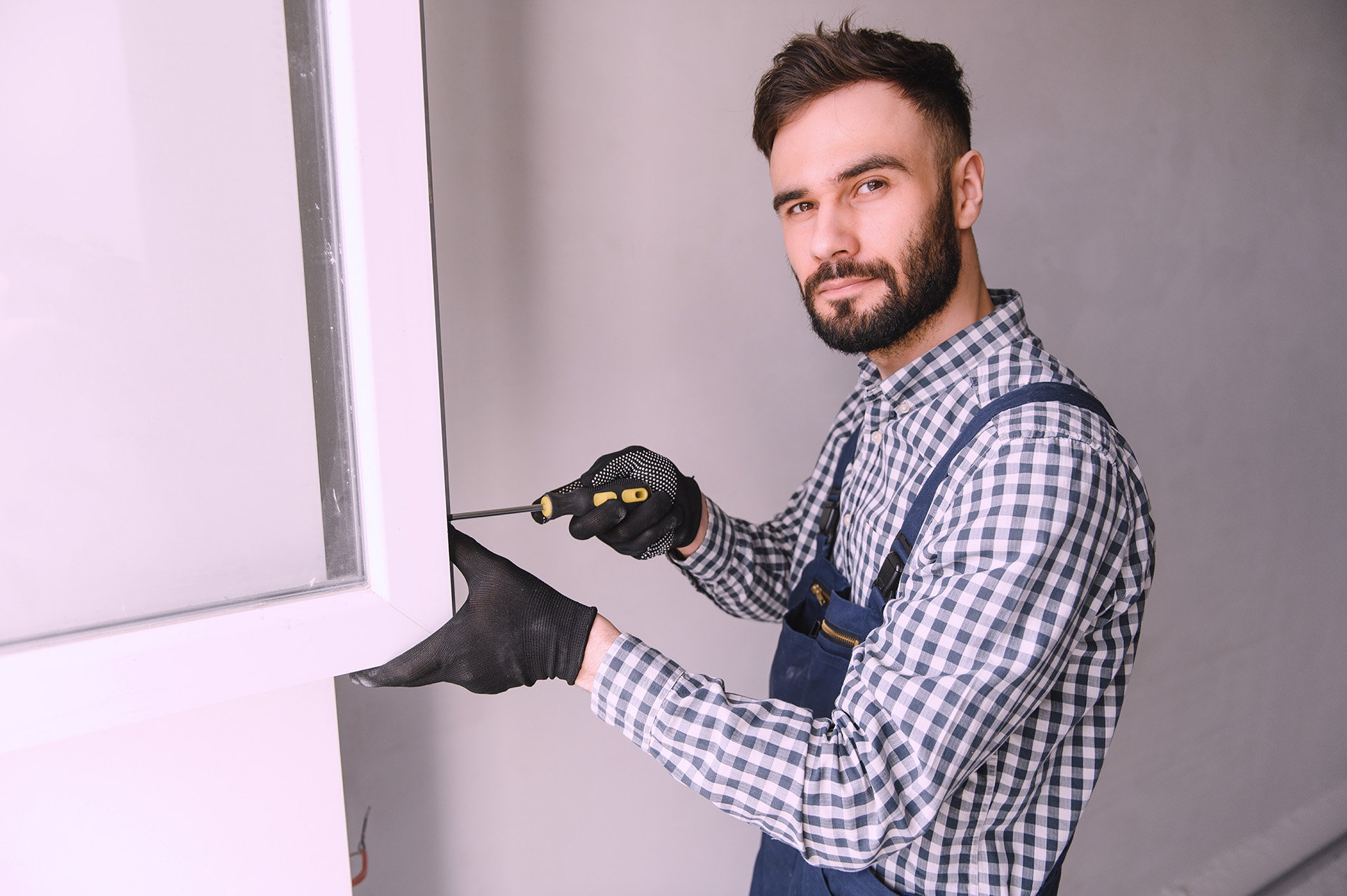 Freundliche:r Mitarbeiter:in des Unternehmens in Arbeitskleidung, lächelnd in die Kamera blickend