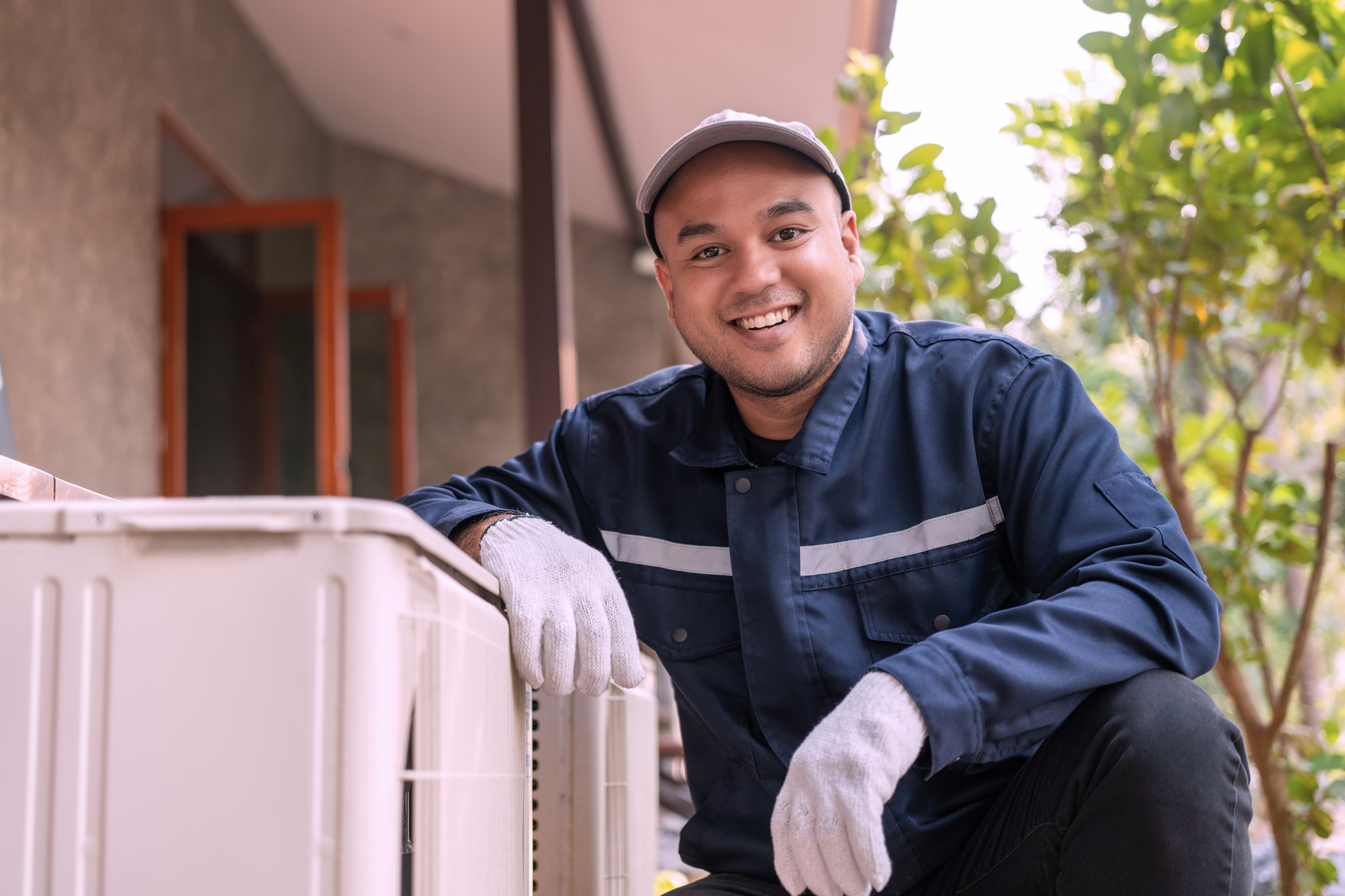 Freundliche:r Mitarbeiter:in des Unternehmens in Arbeitskleidung, lächelnd in die Kamera blickend